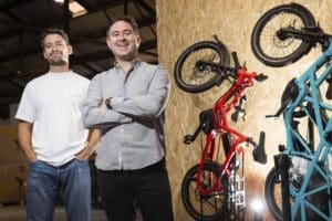 Ben and Dan Carr standing with e-bikes