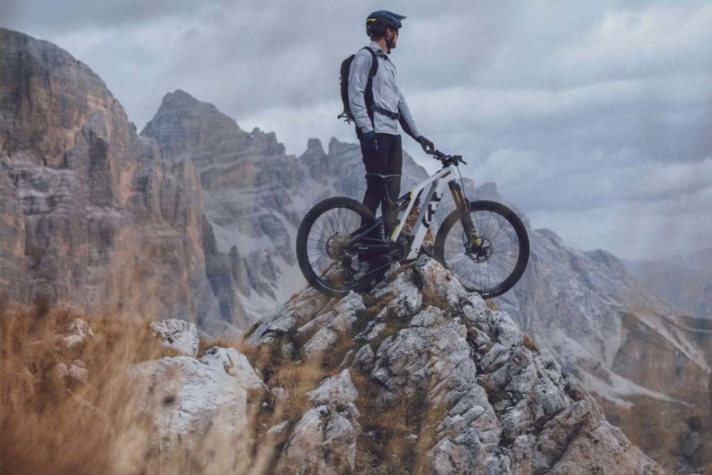 Man standing on mountain with mountain bike