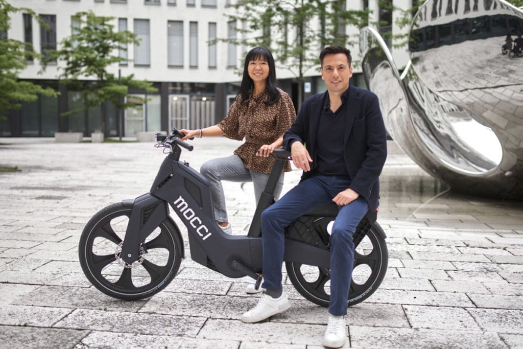 Man and woman posing with Mocci e-bike