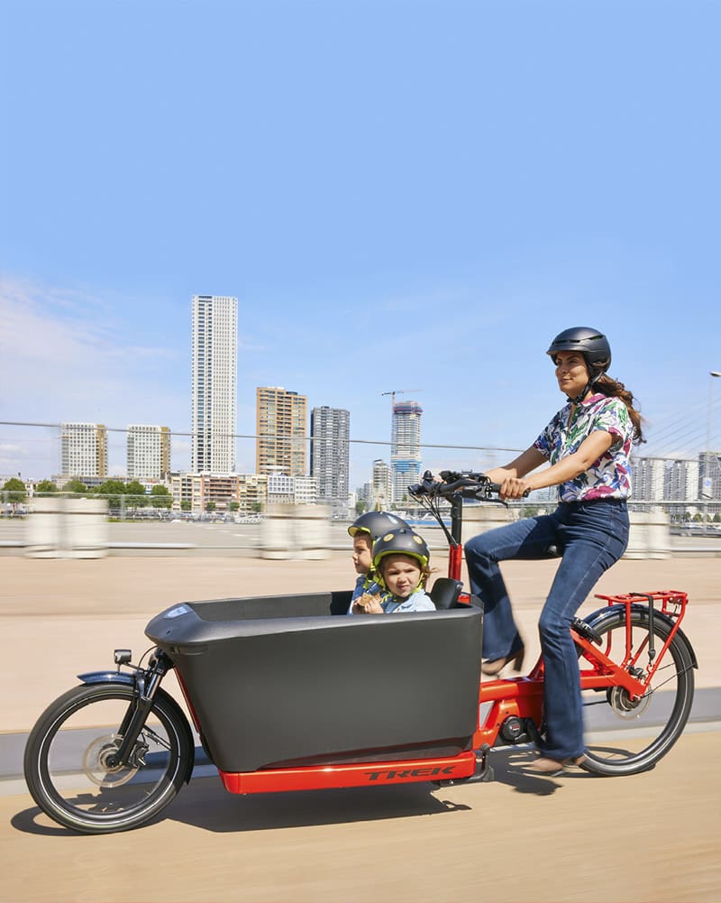 Woman riding e-cargo bike with child in the front