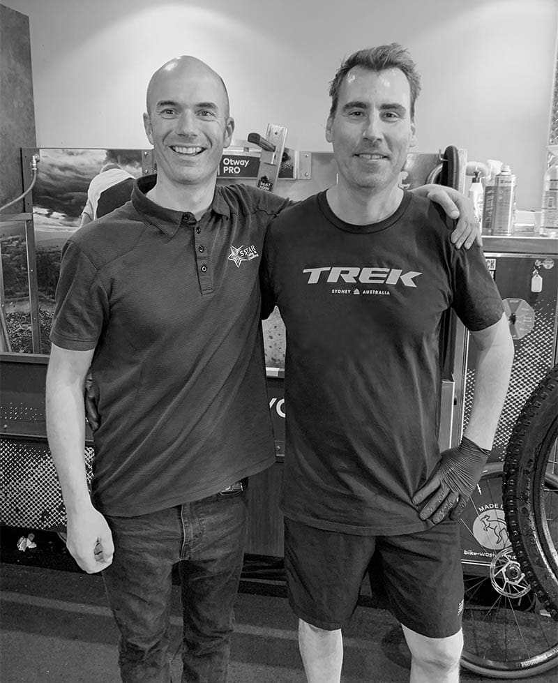 Portrait of two men standing in bike mechanic training facility
