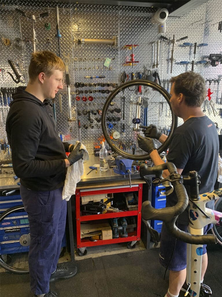 Two people working in bike mechanic workshop