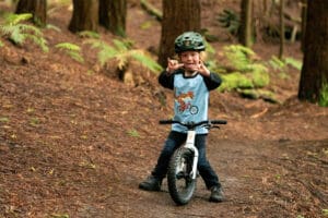 Child riding MTB balance bike on bush track