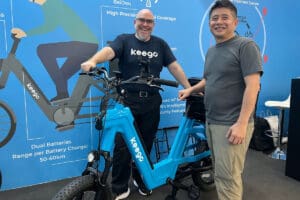 Two men standing with ebike