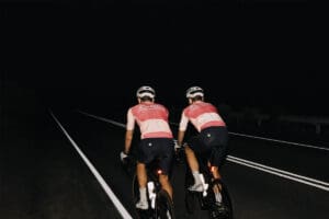 Two people riding on road at night