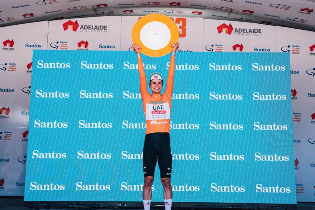 Cyclist holding up winning trophy