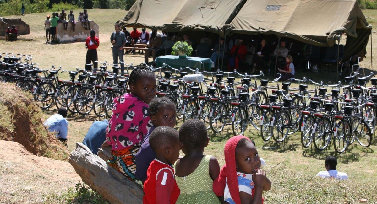 Distribution ceremonies like this are not required or organised by World Bicycle Relief, but by the recipient communities who want to celebrate with singing, dancing and smiles all round. Receiving a hundred brand new, high quality bicycles is a rare, life-expanding opportunity.
WBR founder FK day is standing with the microphone in the background. Local dignitaries are sheltering in the tent – the sun was hot!