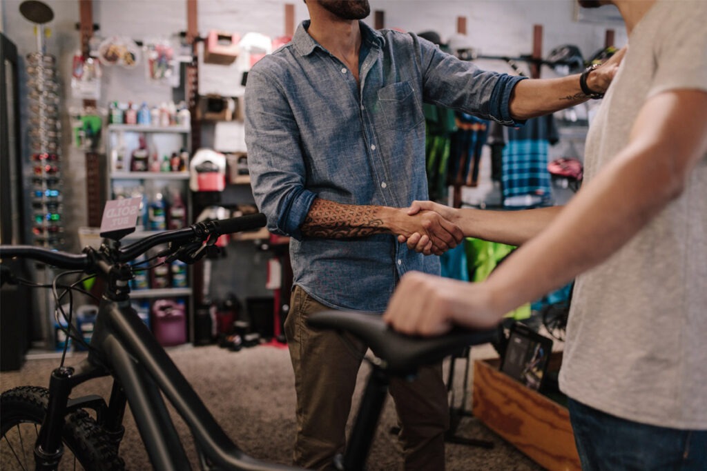 Two people shaking hands in bicycle shop