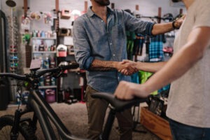 Two people shaking hands in bicycle shop