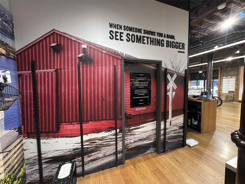 Large image of red barn displayed on bike store interior wall