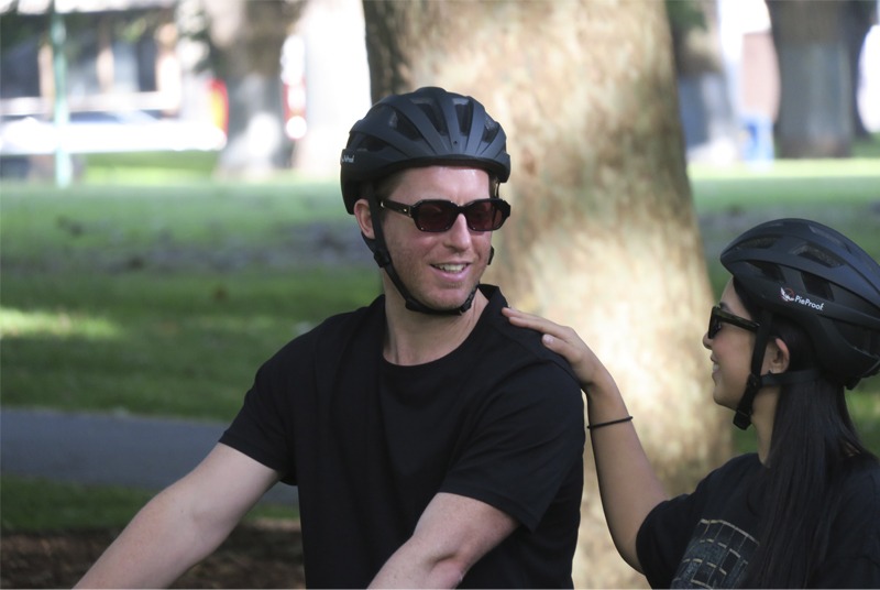 Two people wearing bike helmets in a park