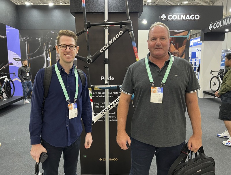 Two men standing in bicycle expo auditorium