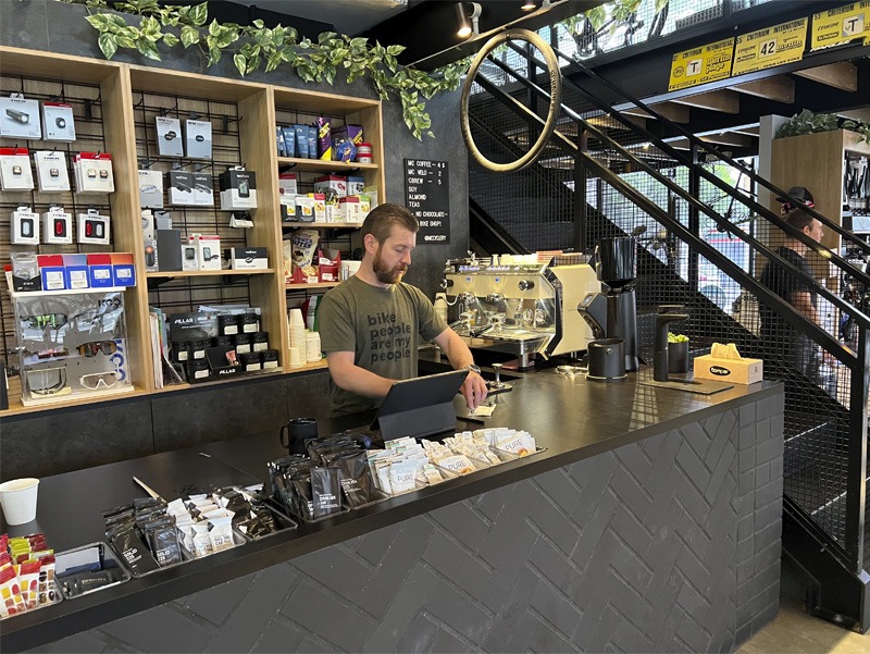 Interior view of bicycle shop, person behind counter.