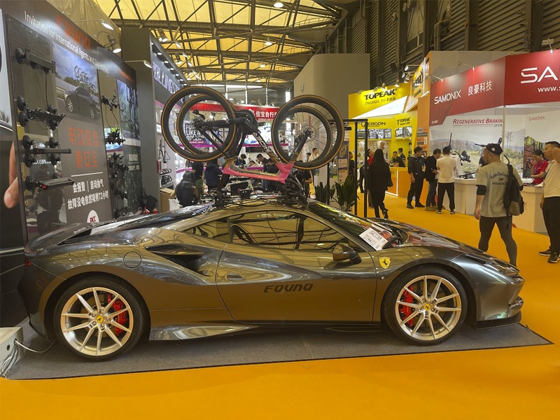 Ferrari on display with two bicycles mounted on the roof