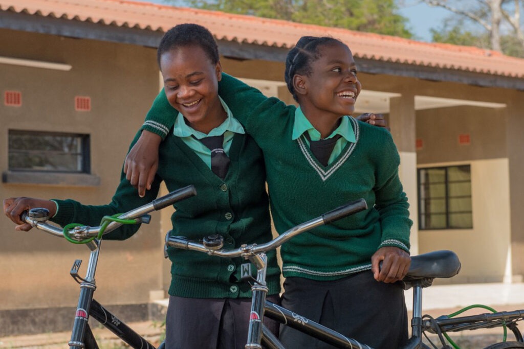 Two South African teenage schoolgirls with bicycles.