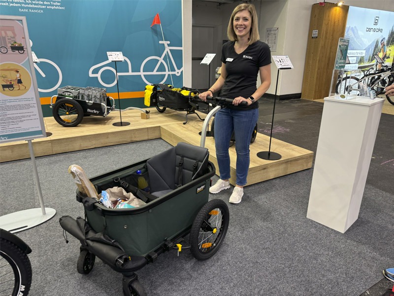 Woman posing with bike trailer that's converted into a stroller