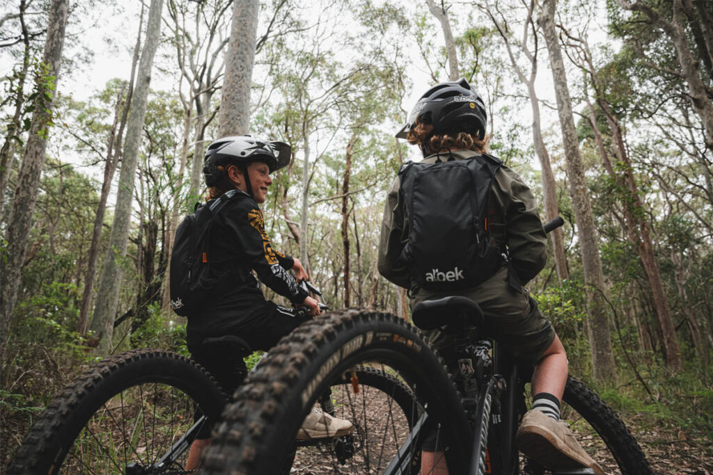 Two young people on mountain bikes in a bush setting