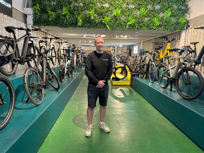 Man facing camera standing in bike shop