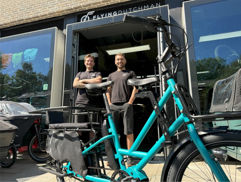 Two people and a bicycle in front of bike shopfront