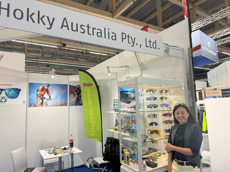 Woman standing at a stall displaying sunglasses in bicycle expo.