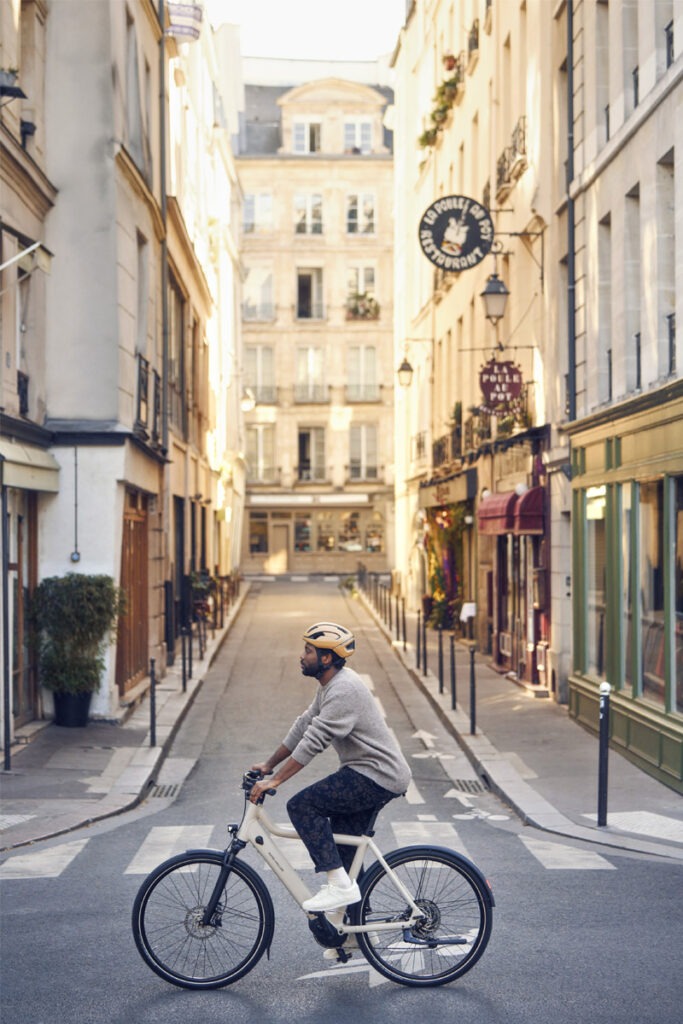 Person riding e-bike through cityscape.