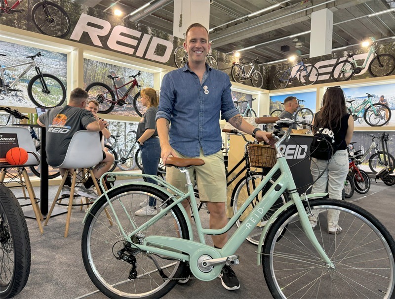 Man standing with bicycle at bike expo