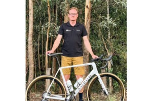 Portrait of man standing with bike