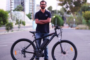 Portrait of man standing with bike