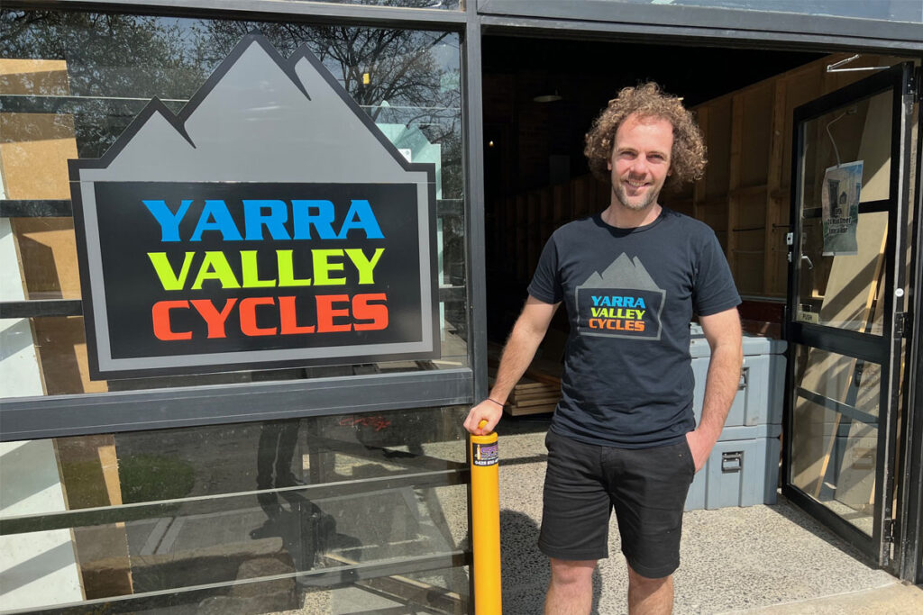 Man standing at the front of a bike shop.