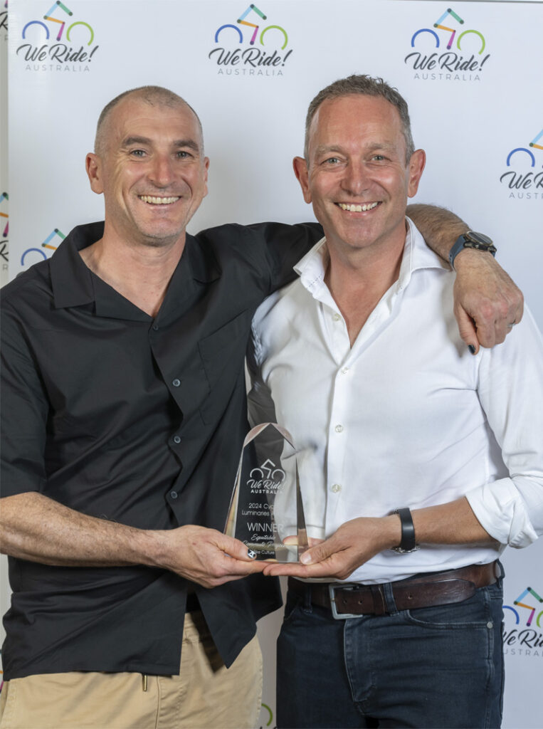 Two men both holding an award.