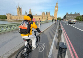 Person riding bike accross London bridge